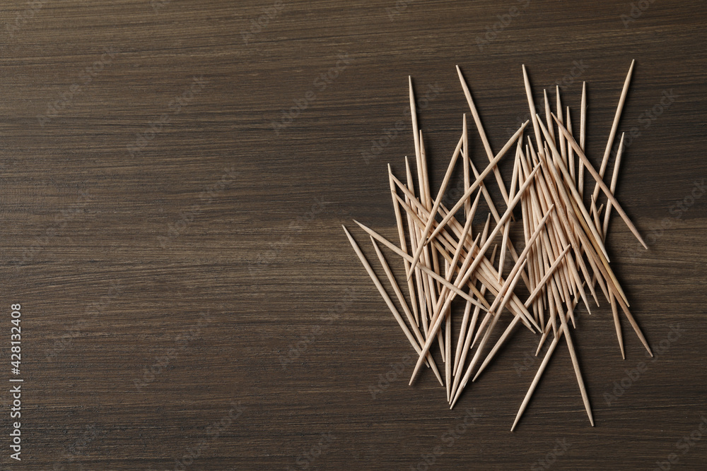 Disposable toothpicks on wooden background, flat lay. Space for text Disposable toothpicks on wooden background, flat lay. Space for text