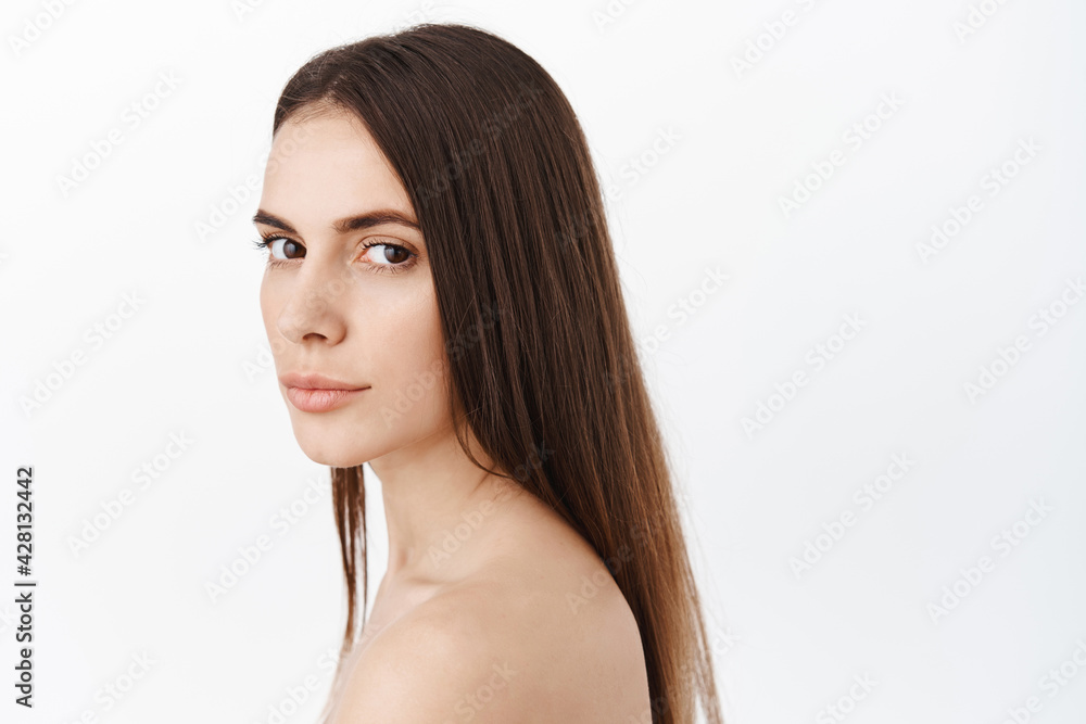 Natural beauty woman with healthy long hair, pure hydrated and clean skin, nude natural facial without make up, shower look, turn head at camera with determined face expression Natural beauty woman with healthy long hair, pure hydrated and clean skin, nude natural facial without make up, shower look, turn head at camera with determined face expression