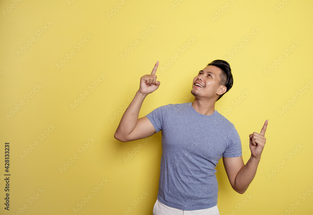 man wearing casual t-shirt smile expression showing blank space. thinking idea isolated on a yellow color background man wearing casual t-shirt smile expression showing blank space. thinking idea isolated on a yellow color background