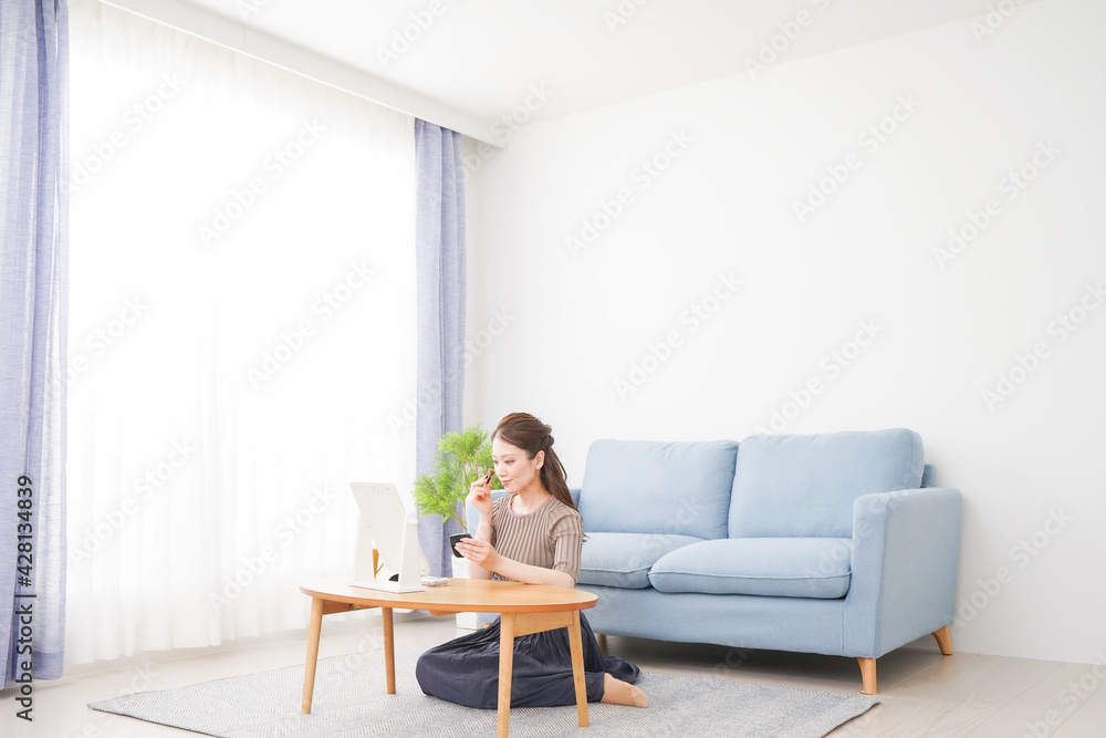 一人暮らしの部屋で化粧をする女性 一人暮らしの部屋で化粧をする女性