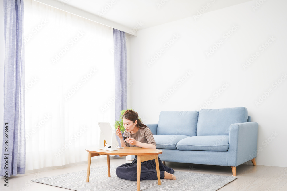 一人暮らしの部屋で化粧をする女性 一人暮らしの部屋で化粧をする女性