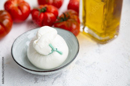 Burrata cheese, tomatoes and olive oil to make a traditional italian salad. photo