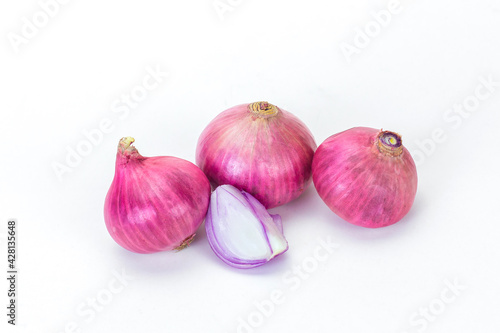 Shallots and pieces of peel are put on white table as background. It is a Thai onion, Thai herb.