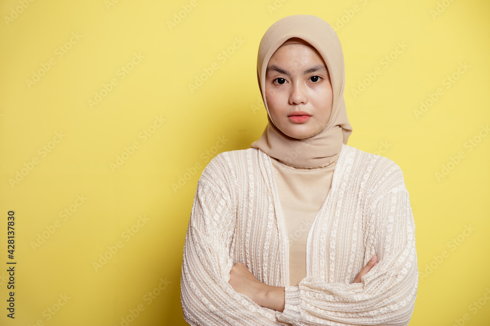 beautiful hijab women crossed arms looking at the camera isolated on a yellow background beautiful hijab women crossed arms looking at the camera isolated on a yellow background