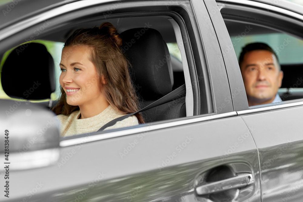transportation, vehicle and people concept - happy smiling female driver driving car with male passenger transportation, vehicle and people concept - happy smiling female driver driving car with male passenger