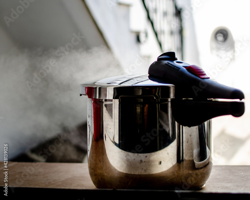 A pressure cooker releasing steam photo