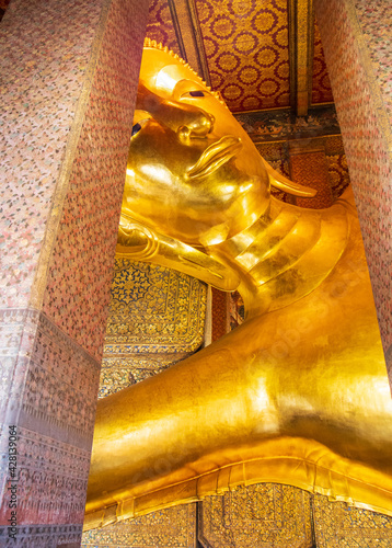 Vertical shot of the Reclining Buddha in Wat Phra Chetuphon (Wat Pho) temple Bangkok, Thailand photo