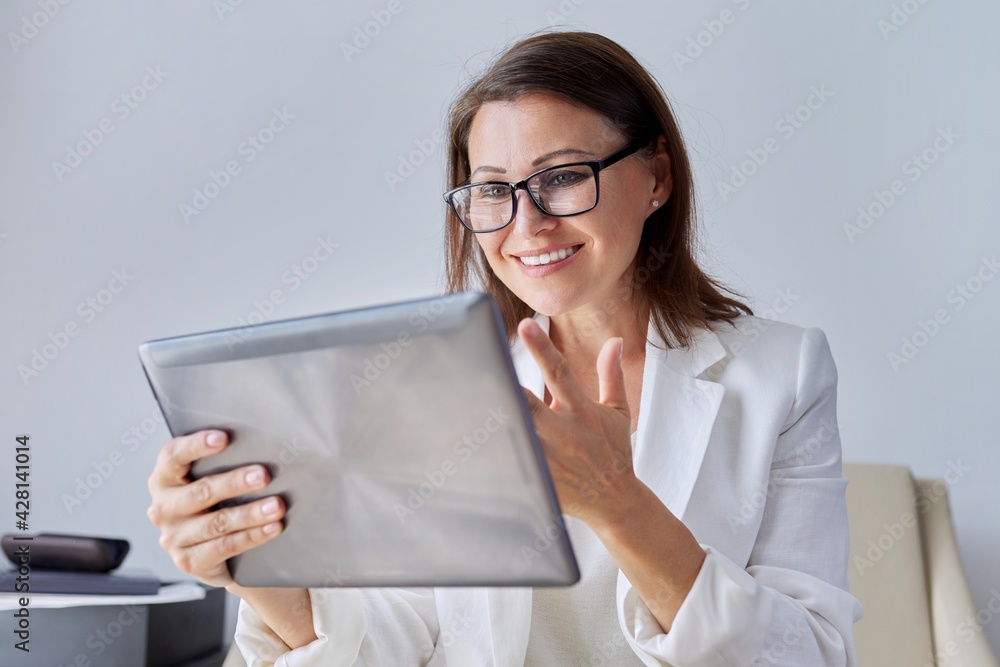 Talking businesswoman looking at screen of digital tablet Talking businesswoman looking at screen of digital tablet