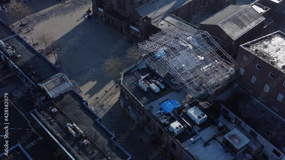 Aerial overlooking empty quiet church town square building rooftops scaffolding construction at sunrise Aerial overlooking empty quiet church town square building rooftops scaffolding construction at sunrise