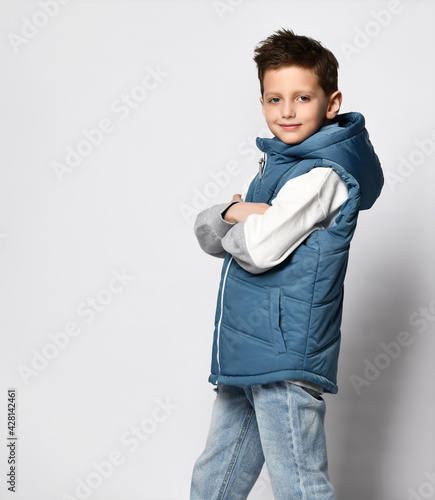 Bilde på lerret teenage boy in a blue in puffer waistcoat, sleeveless down jacket with a zipper and jeans
