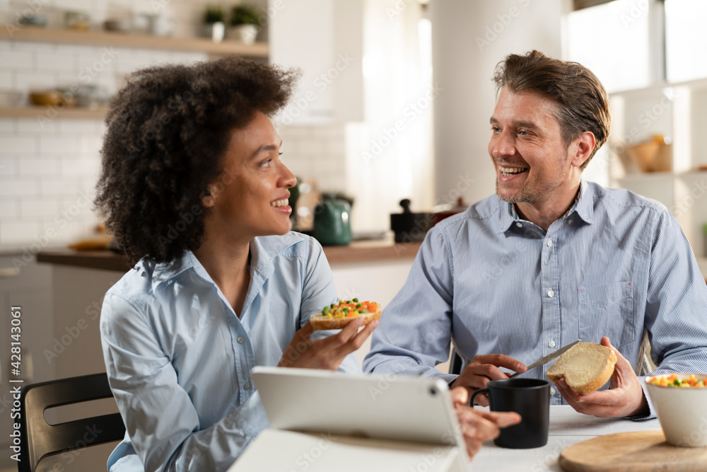 Loving couple drinking coffee and eating sandwich. Happy smiling wife enjoy in the morning with her husband. Loving couple drinking coffee and eating sandwich. Happy smiling wife enjoy in the morning with her husband.