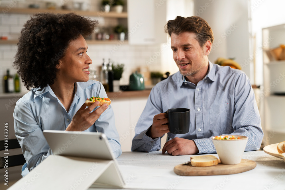 Loving couple drinking coffee and eating sandwich. Happy smiling wife enjoy in the morning with her husband. Loving couple drinking coffee and eating sandwich. Happy smiling wife enjoy in the morning with her husband.