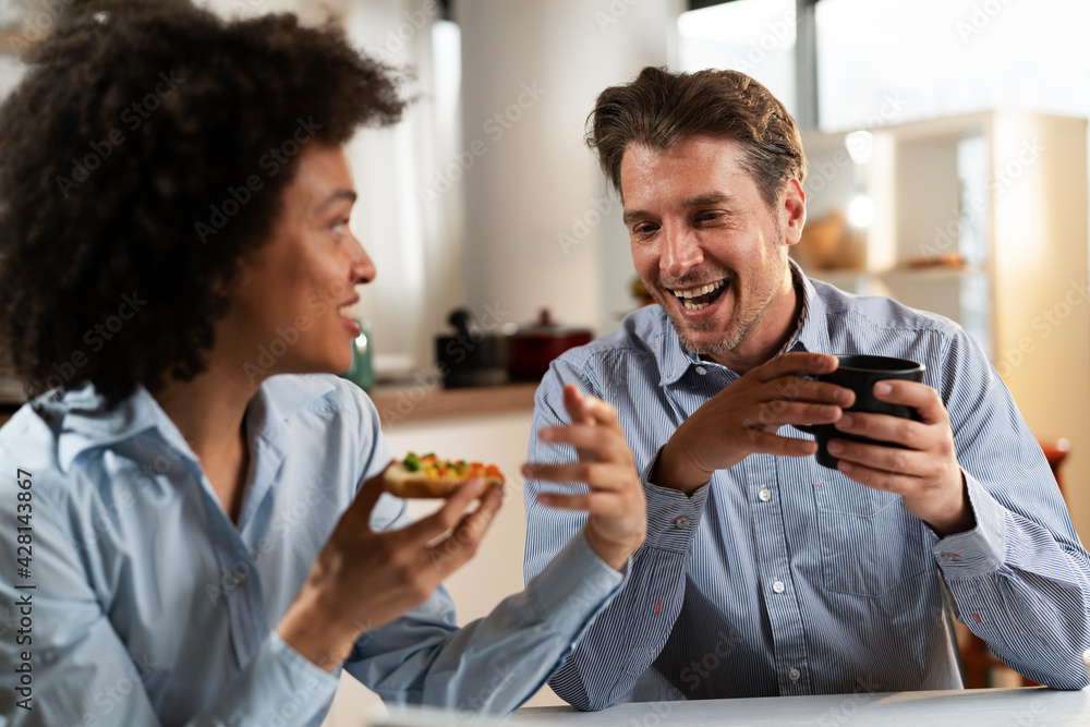 Loving couple drinking coffee and eating sandwich. Happy smiling wife enjoy in the morning with her husband. Loving couple drinking coffee and eating sandwich. Happy smiling wife enjoy in the morning with her husband.