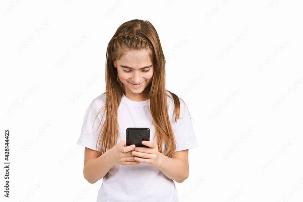 Children portrait in white t-shirt. Studio isolated concept. Girl with black smartphone. Happy people Children portrait in white t-shirt. Studio isolated concept. Girl with black smartphone. Happy people