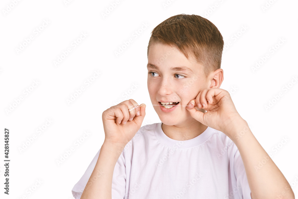 Children portrait in white t-shirt. Studio isolated concept. Boy usin toooth floss. Orthodontist medicine treatment Children portrait in white t-shirt. Studio isolated concept. Boy usin toooth floss. Orthodontist medicine treatment