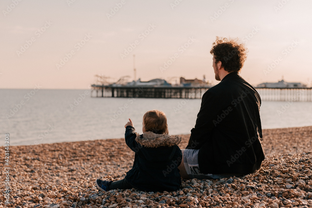Father and son sitting on the beach