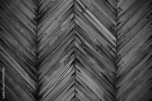 Old black wooden planks in the form of a herringbone pattern. Close-up. Background. Texture.