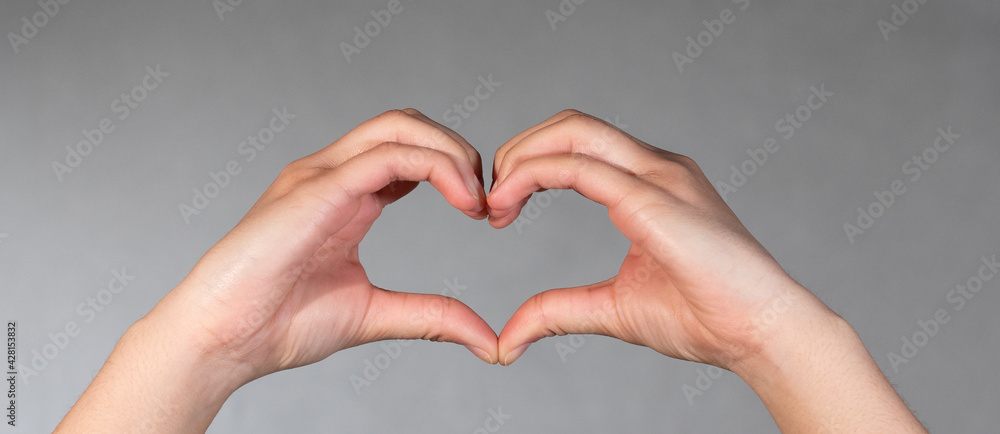 Obraz premium Hand and fingers shapes a heart. Valentine and romantic gesture.