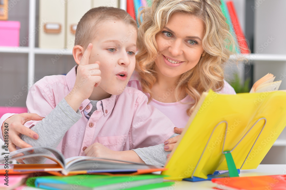 Mother with her son doing homework at home Mother with her son doing homework at home