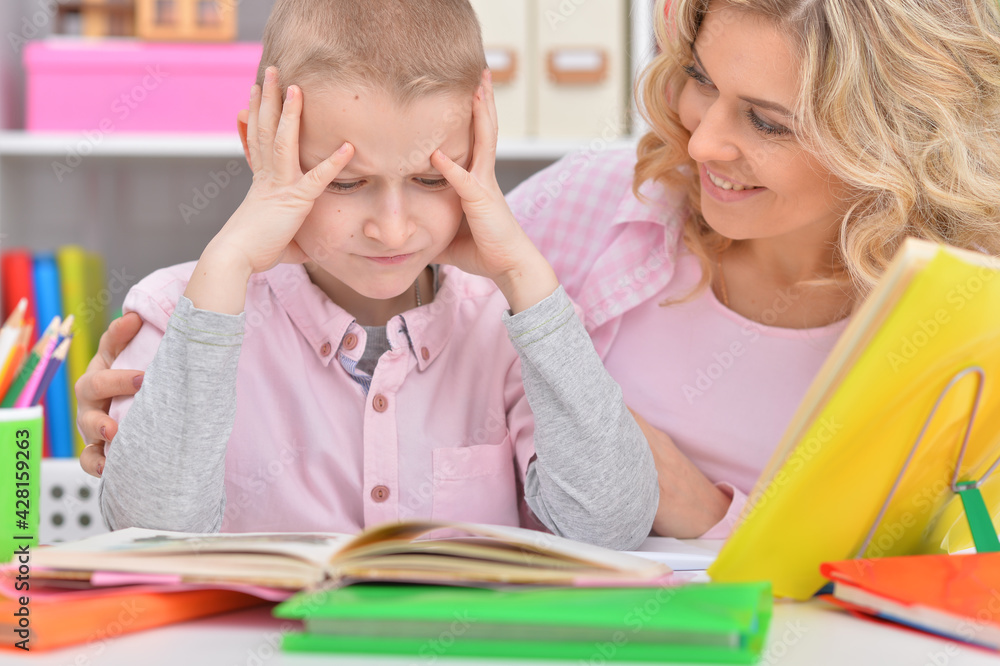 Fototapeta premium Mother with her son doing homework at home