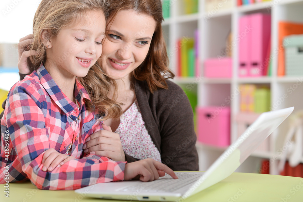 happy mother and daughter using laptop together happy mother and daughter using laptop together