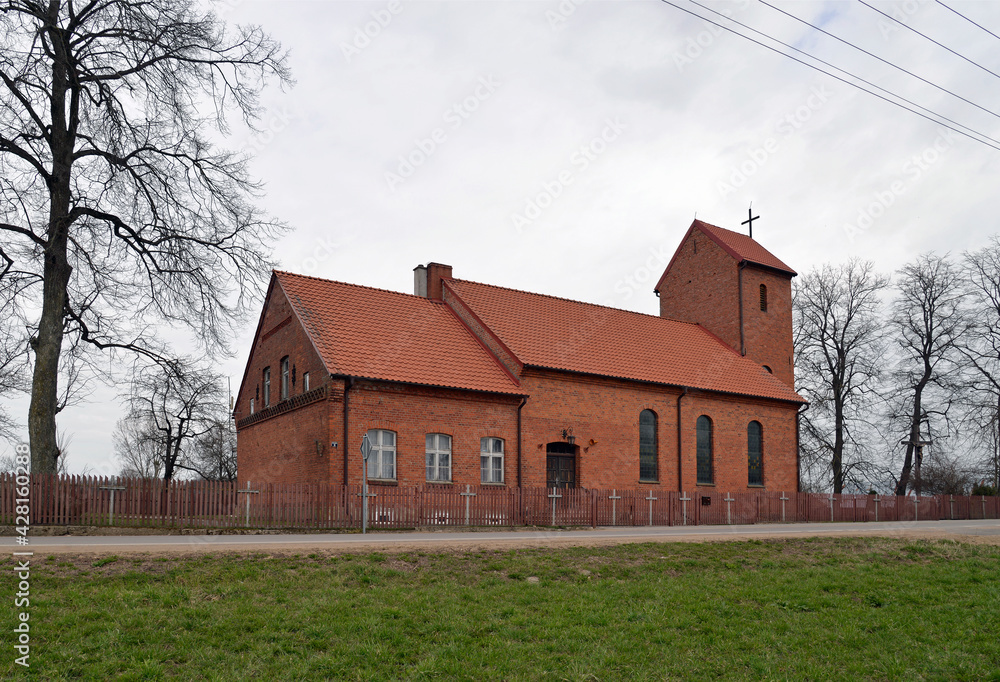 Built in the neo-Gothic style of red ceramic brick in 1921, the Catholic Church of St. Andrew the Apostle in the village of Prawdziska in Masuria, Poland. The photos show a general view of the temple.