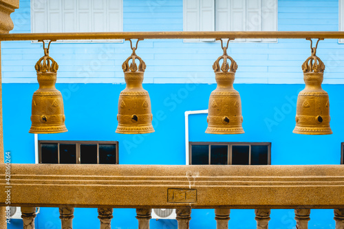 The hanging Golden bells with blue background at Wat Sakhala temple in Samutprakan province ,Thailand  photo