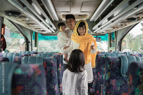 happy asian muslim holiday trip riding a bus together with family