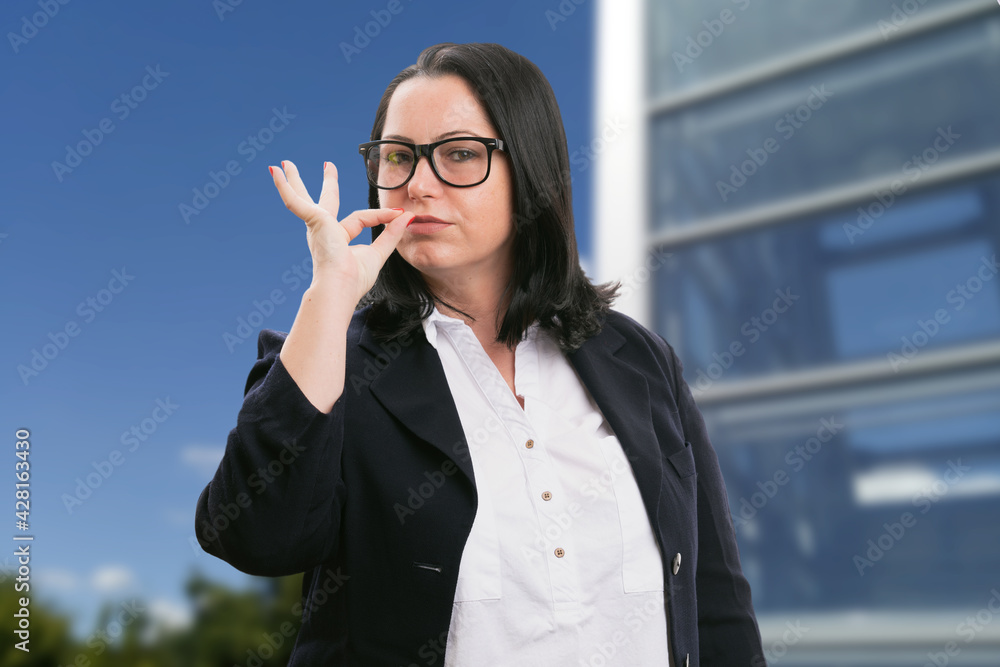 Businesswoman in corporate suit making chef kiss gesture Businesswoman in corporate suit making chef kiss gesture
