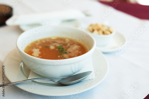 traditional chicken soup served in a bowl over white background © Raisa Kanareva