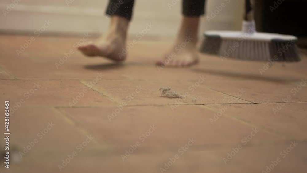 Person sweeps dirty dusty floor with broomstick Person sweeps dirty dusty floor with broomstick