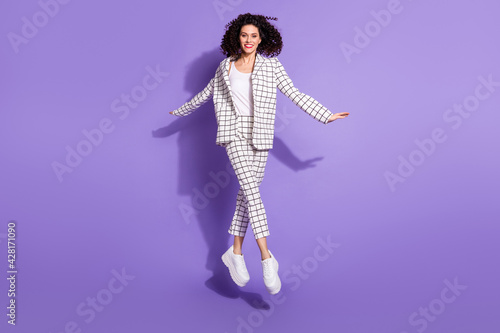 Full length photo of young excited girl happy positive smile active jump up isolated over violet color background