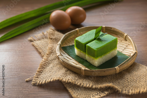 Selective focus of Kuih Seri Muka, traditional Malaysian two layered dessert with steamed glutinous rice forming the bottom half and a green custard layer made with pandan juice. photo