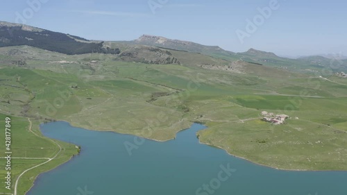 Lake Prizzi in the heart of the Sicani mountains in Sicily. Lush vegetation with wheat crops. Rurality in Sicily. Green in Sicily in spring. Relax by the lake. Migratory birds. photo