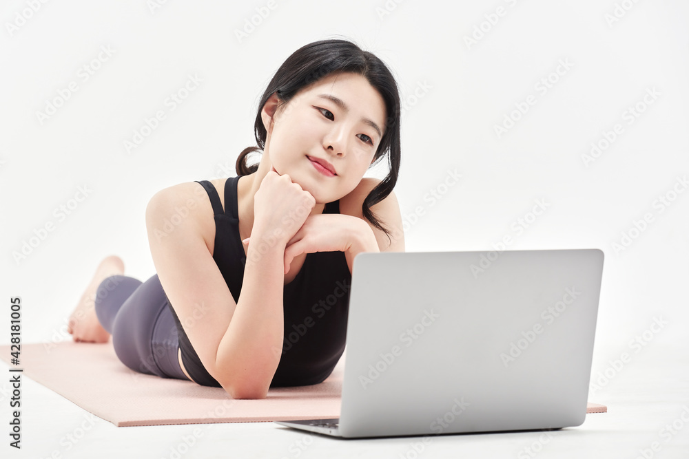 Asia korean girl long haired beautiful pilates or yoga athlete does a graceful pose while wearing a tight sports outfit against a white background in a studio Asia korean girl long haired beautiful pilates or yoga athlete does a graceful pose while wearing a tight sports outfit against a white background in a studio