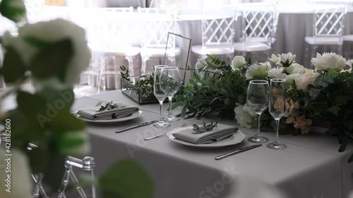 glasses, plates and utensils with napkins on the table in the white room. serving for the holiday.