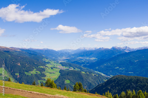 mountain valley with stones and meadows above, lush forests below and below rivers and villages