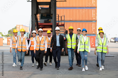 portrait factory workers or engineers team walking in containers warehouse storage
