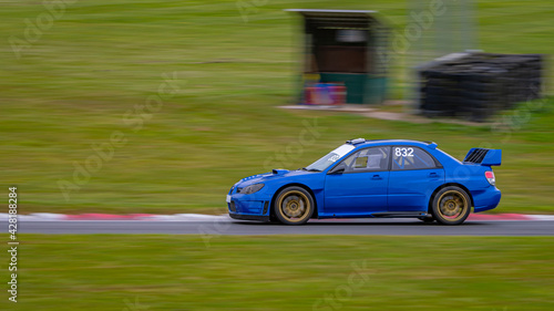 A panning shot of a racing car as it circuits a track.