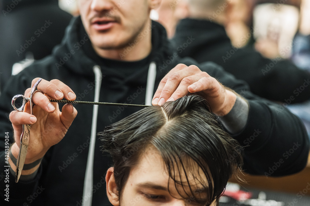 Fototapeta premium Hipster client man visiting in barber shop shaving hair. Modern guy having his hair cut in barbershop.