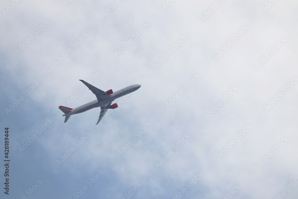 Airplane flying in the blue sky with white clouds. Passenger plane at flight close up, travel concept Airplane flying in the blue sky with white clouds. Passenger plane at flight close up, travel concept
