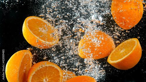 Sliced oranges falling into...