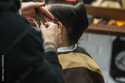 A man in a barbershop.Modern guy having his hair cut in barbershop