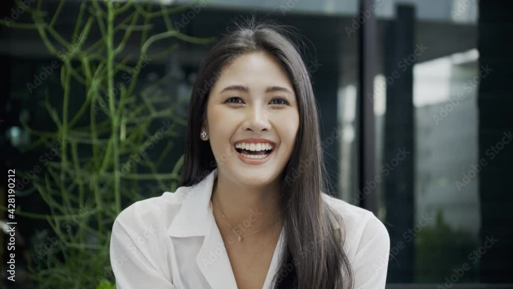 Beautiful Asian woman looking at camera and talking with happy smile. Business women presenting for video call from home With colleagues. Teleconference in office. Concept New normal Beautiful Asian woman looking at camera and talking with happy smile. Business women presenting for video call from home With colleagues. Teleconference in office. Concept New normal