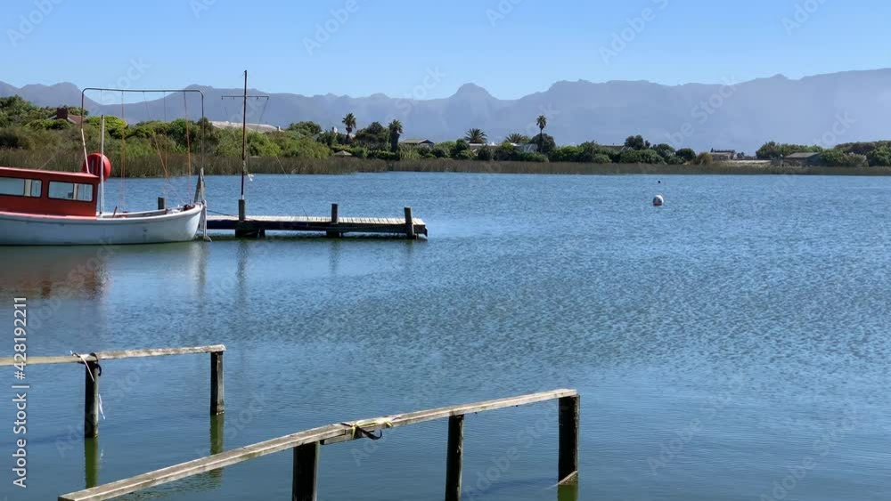 Jetty wooden and boat with wooden water channel guide Zeekoevlei , pond or lake mountain views of the Cape Peninsula Jetty wooden and boat with wooden water channel guide Zeekoevlei , pond or lake mountain views of the Cape Peninsula
