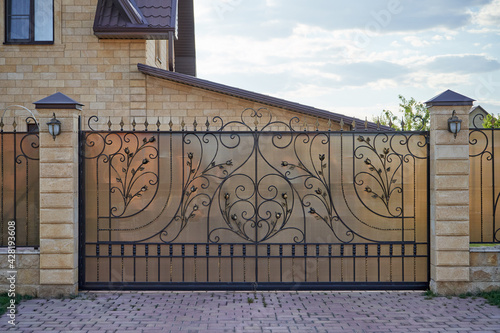 Photography Luxury metal wrought side sliding gates with ornate elements.