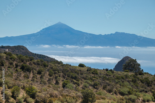 The landscape in the mountains leads to the ocean overlooking the neighbouring island and the volcano. A trip inland to the island of Gomera, Canary Islands. Travel on the paths of Garajonay National 