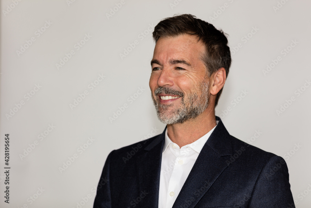 Mature Businessman smiling to a client away. Profile view. He is a winner. Isolated on white. Mature Businessman smiling to a client away. Profile view. He is a winner. Isolated on white.