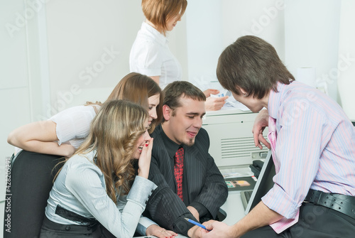 Young business team laugh in front of computer