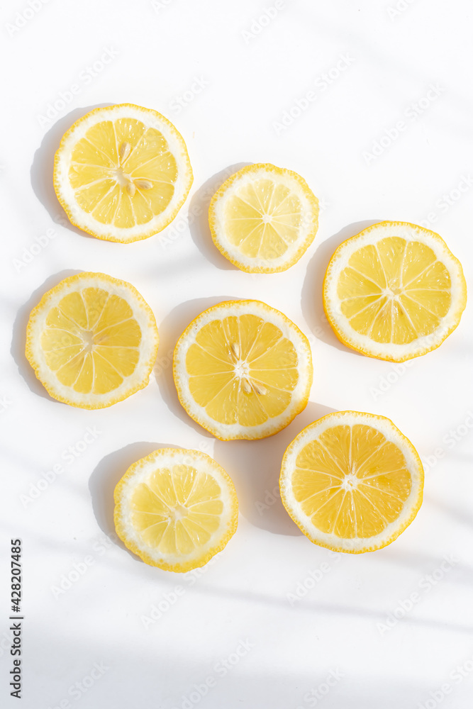 Sliced lemon on a white background . Lemon layout. Sliced fruit. Yellow color. White background. Light and shadow. Citrus. Copy space Sliced lemon on a white background . Lemon layout. Sliced fruit. Yellow color. White background. Light and shadow. Citrus. Copy space